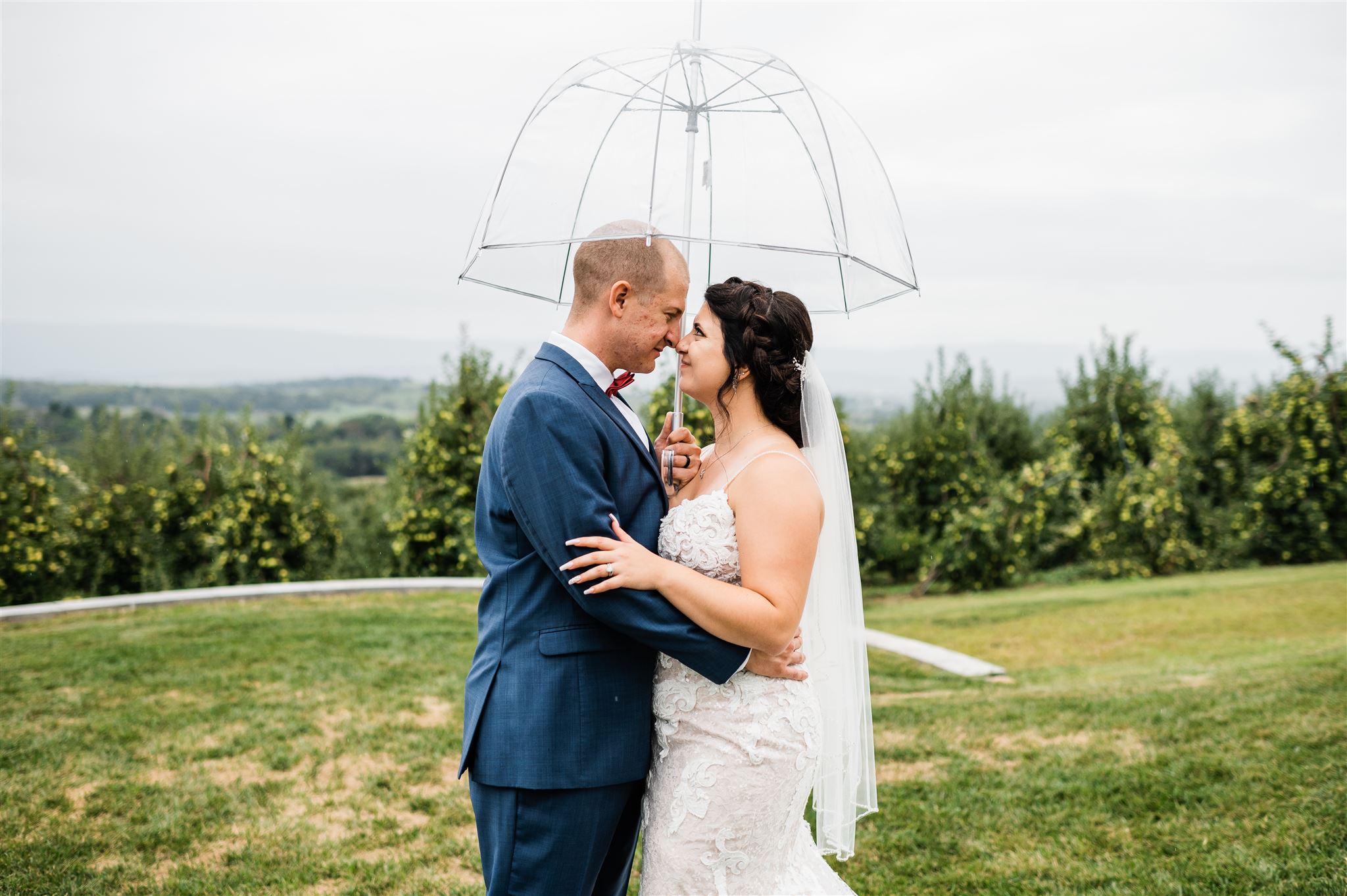 bride and groom kissing under an umbrella as they embrace