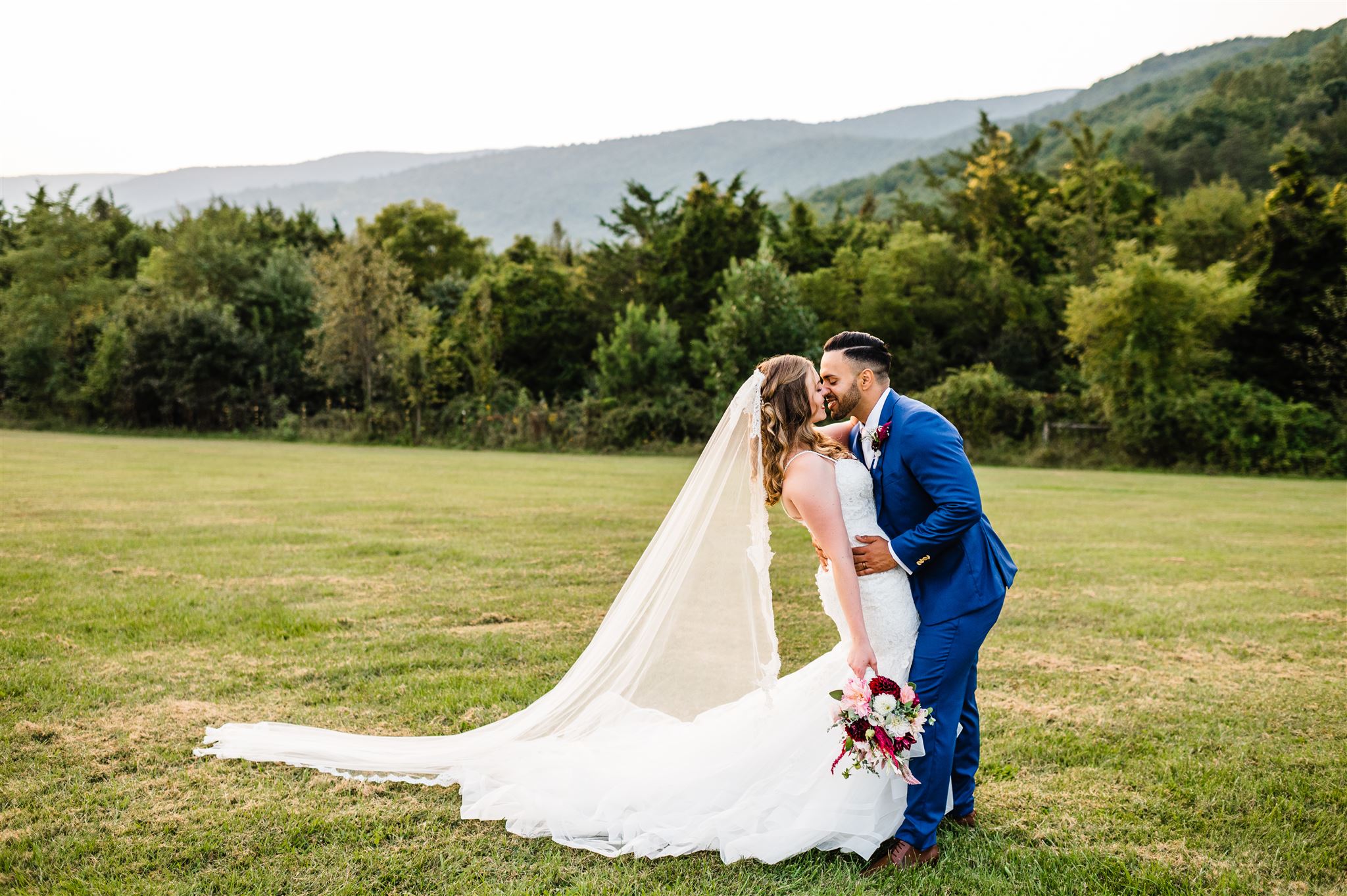 Charlottesville weddin gphotographer captures groom dipping his bride backwards and kissing her passionately for their Shenandoah National Park wedding