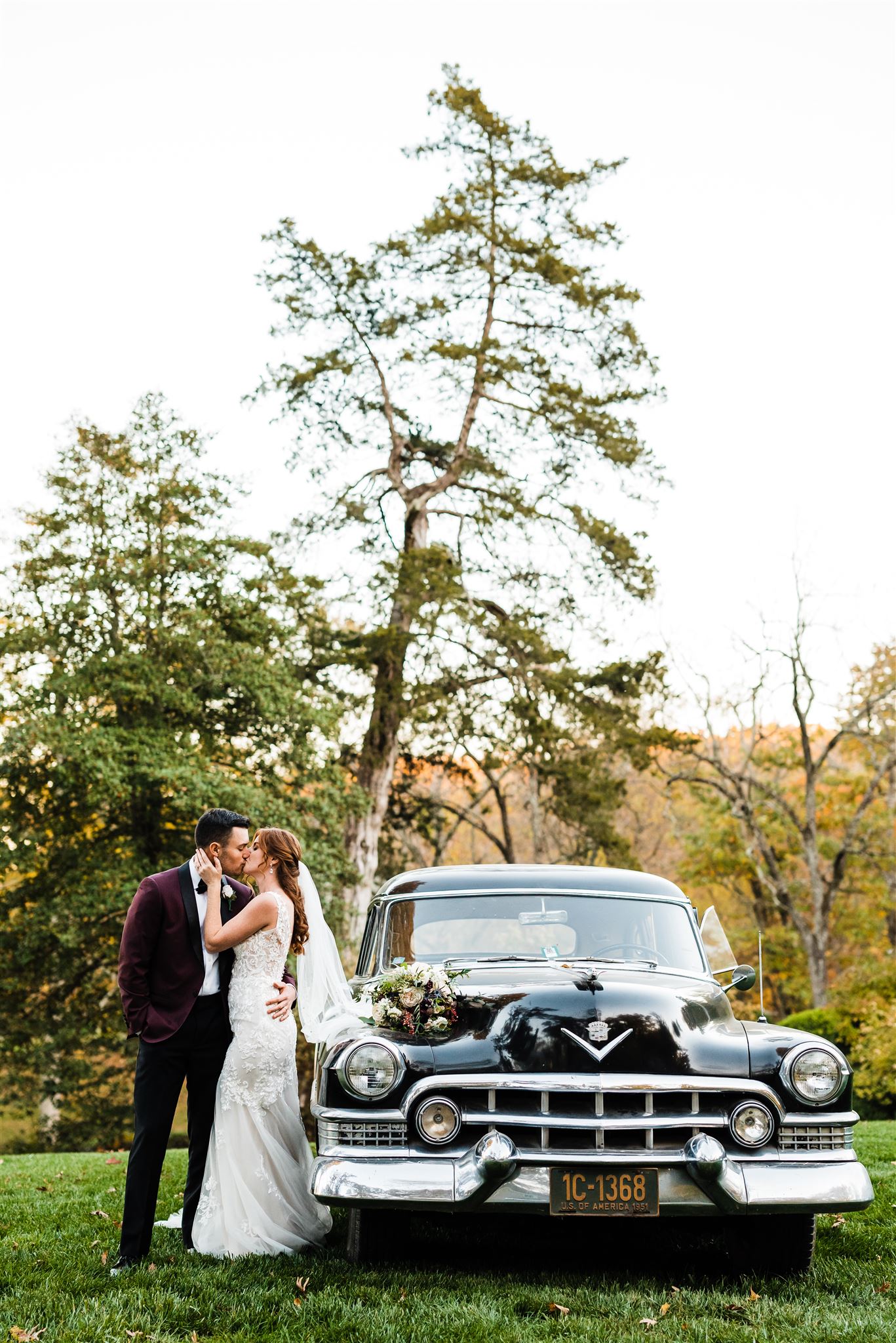 bride and groom kissing one another while standing next to a vintage get away car for their Shenandoah wedding with Charlottesville wedding photographer