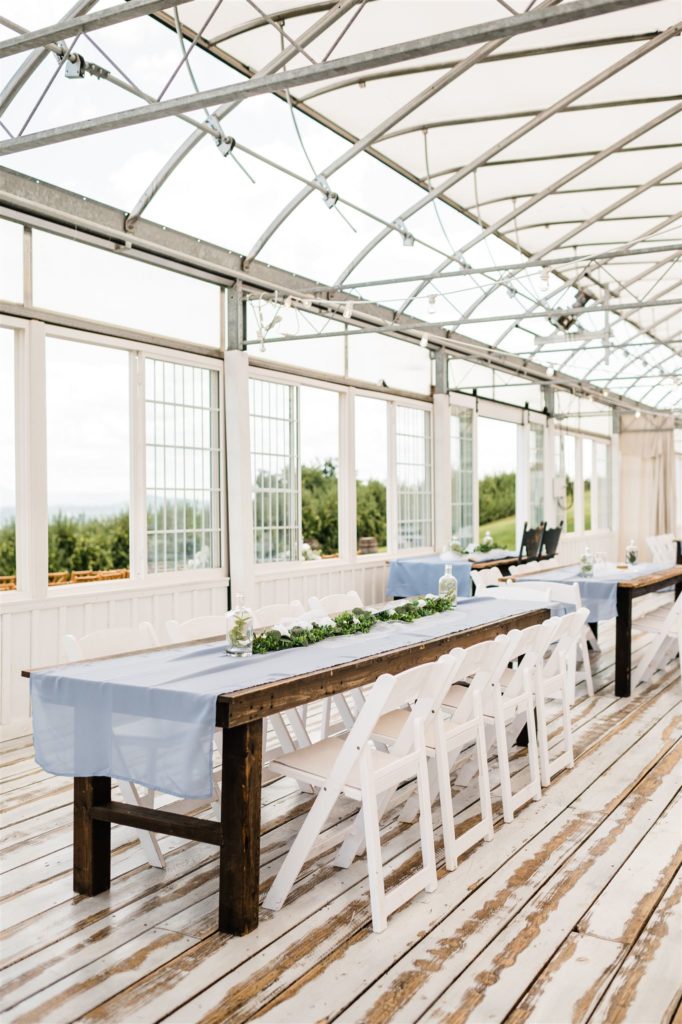Shenandoah wedding venue with reception hall with large windows and white table and chairs with blue accents photographed by Charlottesville wedding photographers