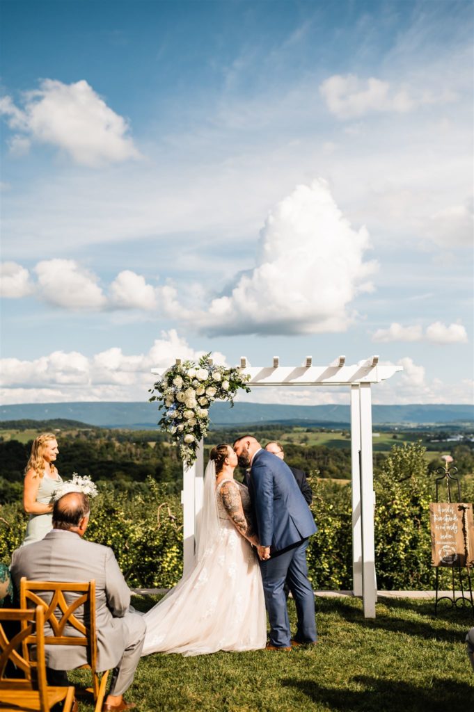 bride and groom kissing at their outdoor wedding ceremony photographed by Charlottesville wedding photographer 
