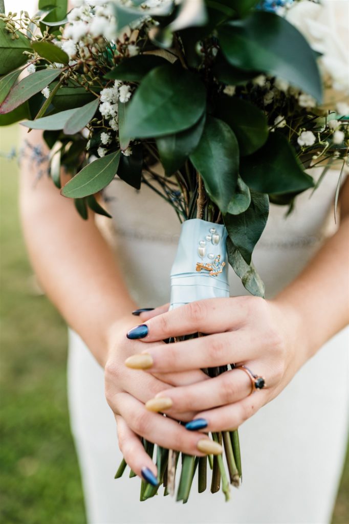 detail shot by Charlottesville wedding photographer of bride holding her blue floral bouquet to her chest