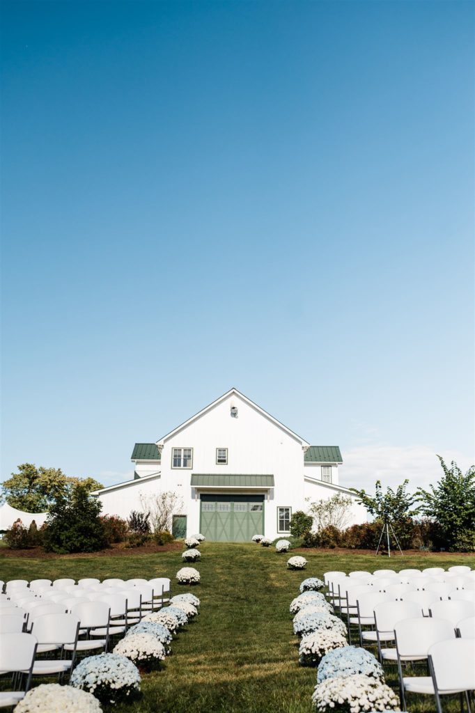 Charlottesville wedding photographer captures carn wedding venue that is painted white with green doors