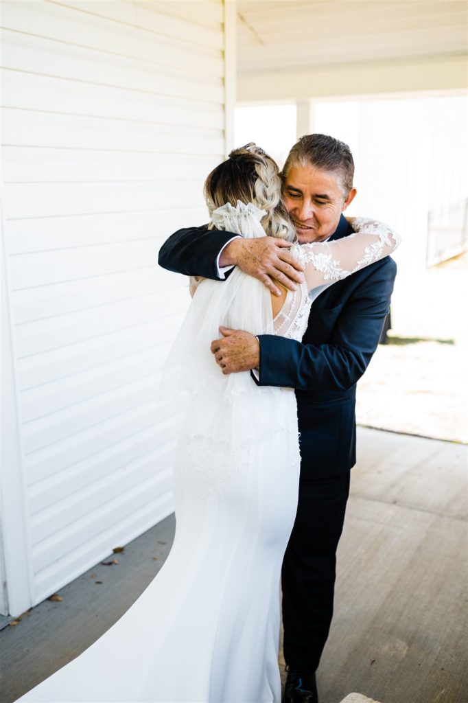 father of the bride hugging the bride after their first look before the wedding day starts captured by Charlottesville wedding photographer