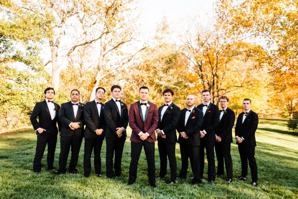 Shenandoah wedding with groom and his groomsmen standing together on the lawn of the wedding venue in a line captured by Charlottesville wedding photographer 