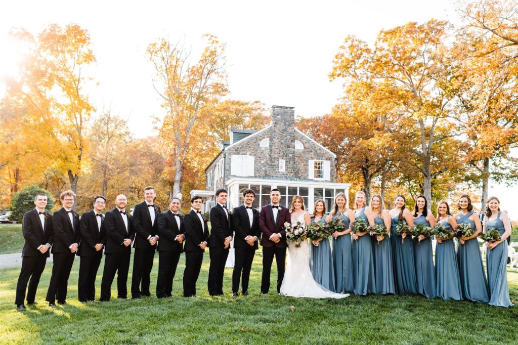 large bridal party posing at outdoor Shenandoah wedding venue with bride and groom at the center captured by Charlottesville wedding photographer 