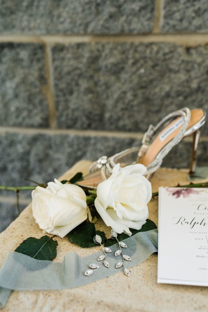 white roses sitting next to brides wedding shoes for Shenandoah wedding flatlay photos
