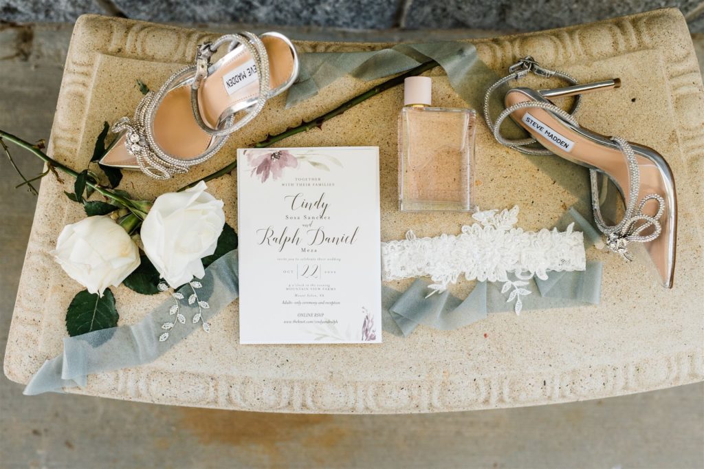 luxury wedding invitations staged with perfumes and florals and bridal shoes photographed by Charlottesville wedding photographer 