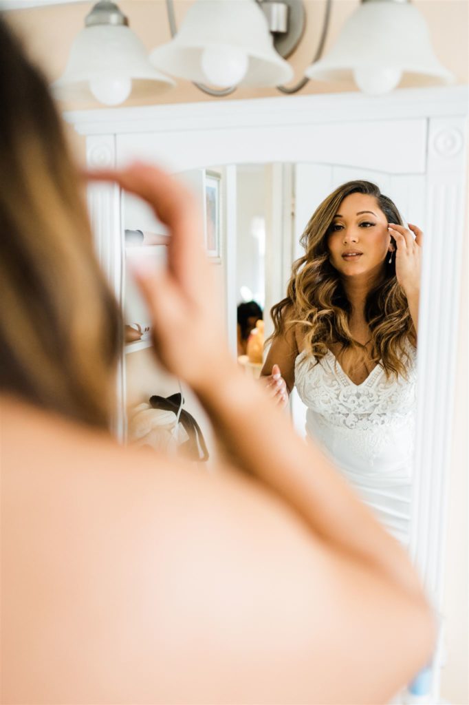 bride getting ready in the mirror in her bridal suite at her Shenandoah wedding venue captured by Charlottesville wedding venue