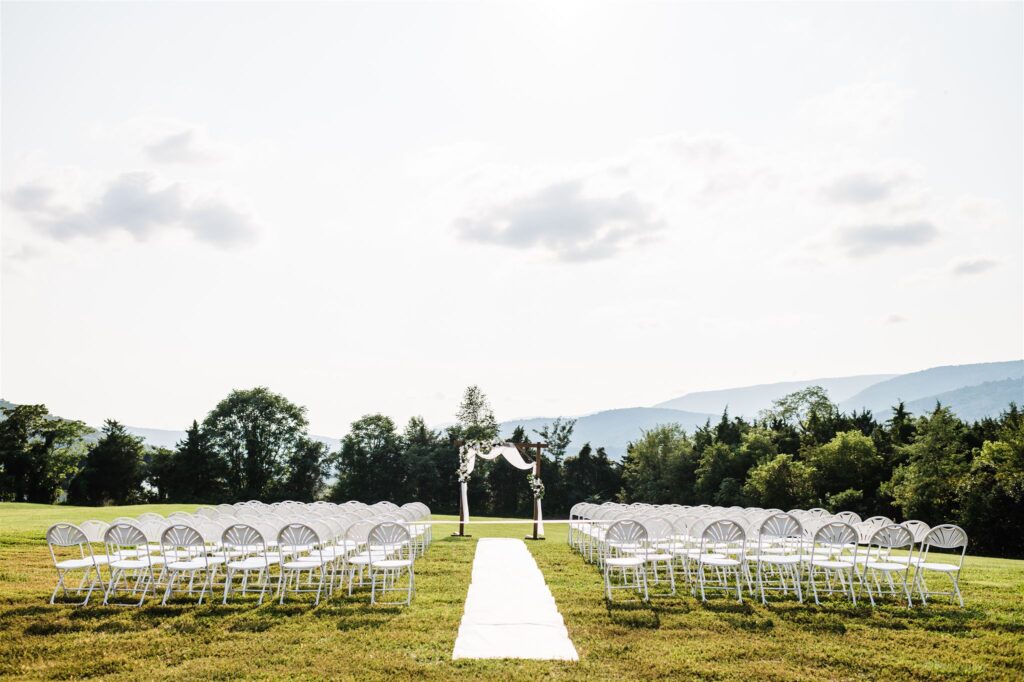 Virginia wedding photographer captures Shenandoah wedding venue outdoor ceremony space with the tree line in the distance in the mountains behind the trees