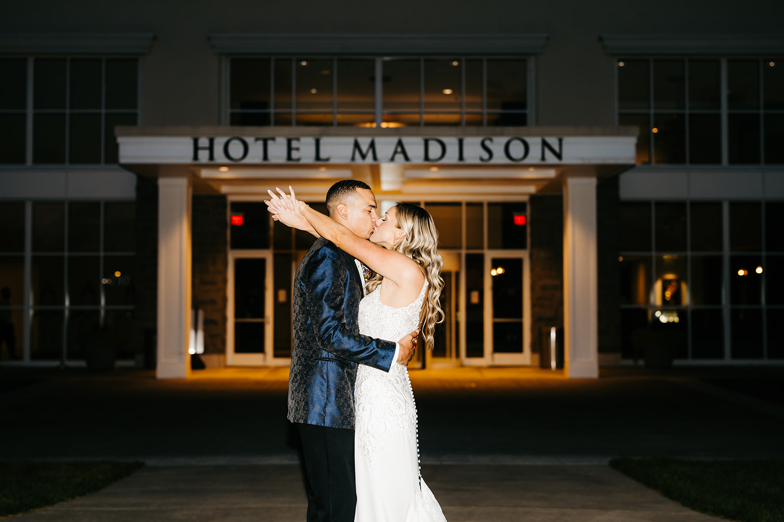 Hotel Madison wedding photos by Charlottesville wedding photographer with bride and groom embracing and kissing outside of the venue