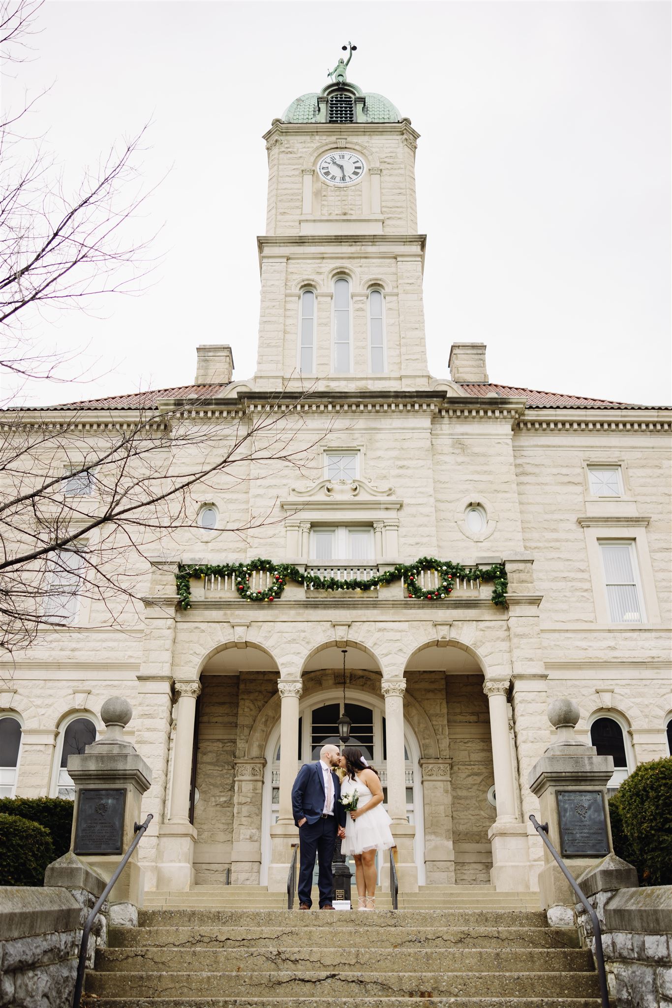 courthouse wedding with bride and groom on the steps of the courthouse smiling at one another captured by Charlottesville wedding photographer