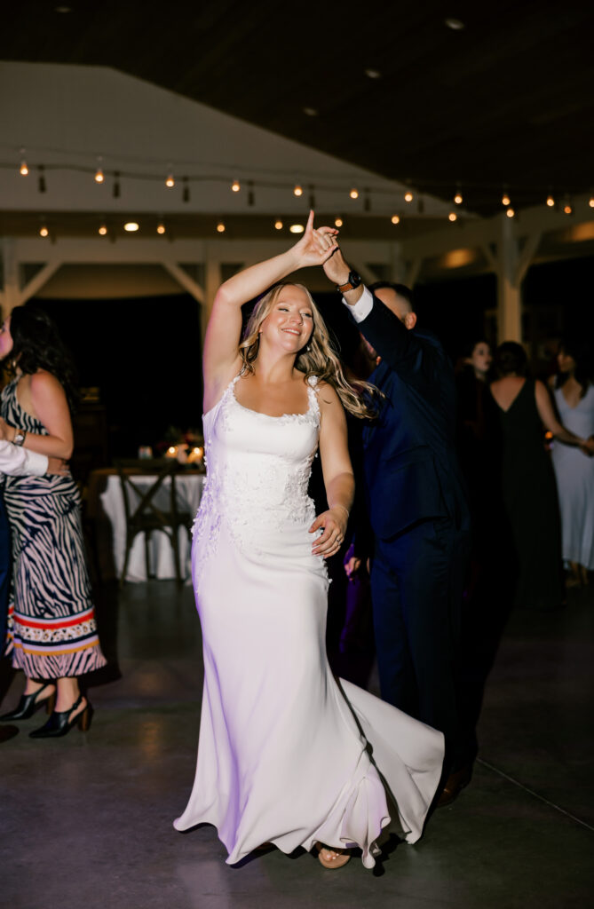 groom twirling his bride and dancing at after party, Seven Springs venue